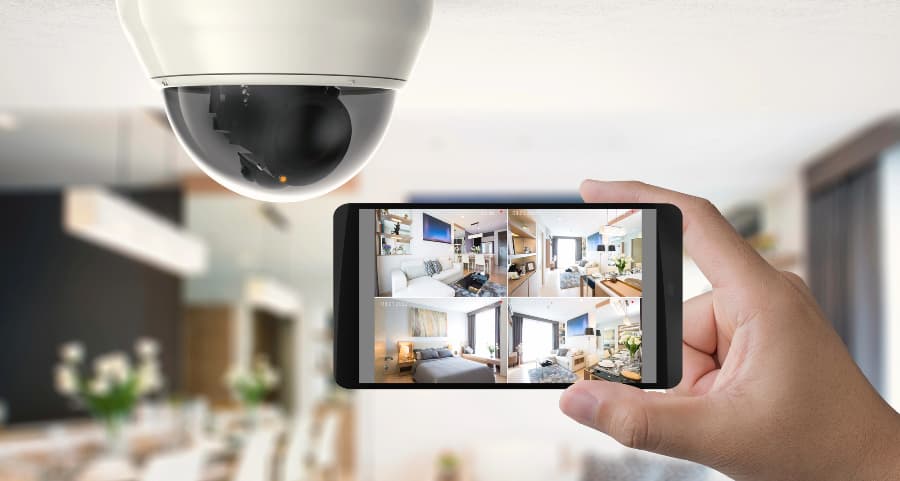 Homeowner holding smartphone with video feed from security cameras in Las Vegas